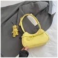 Bolso amarillo tipo dumpling con lazo y correa ajustable en piel granulada - Amarillo