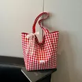 Red and white gingham canvas tote bag with a white lace bow and brand logo tag - Red