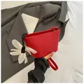 Red woven bucket bag with white flower charm and elegant top handle for summer - Red