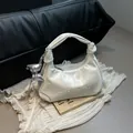 Elegante bolso dumpling crema con colgante de lazo plateado y asa con nudo de moda - Con Colgante / Blanco