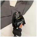 Dettaglio mini borsa in pelle verniciata nera con fiocco e catena argentata - Nero