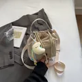 Chic beige nylon drawstring bucket bag with soft pleated design and moon charm accessory - With Ornament / Off White
