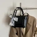 Sac seau noir brillant chic avec poignée torsadée et détail de nœud en dentelle - Noir