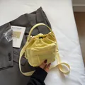 Bright yellow nylon drawstring bucket bag with adjustable strap and front zipper pocket - No Pendant / Light Yellow