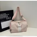 Dettaglio macro della borsa a tracolla in nylon rosa con tre strisce bianche e cinghia - Rosa