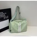 Dettaglio della borsa toast verde chiaro in nylon con strisce bianche e tracolla regolabile - Verde