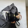 Bolso cubo negro con textura de cocodrilo, cierre dorado, oso de peluche y cinta - Negro