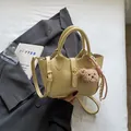 Bolso cubo amarillo pálido con textura de cocodrilo y colgante de osito - Amarillo
