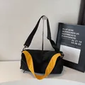 Minimalistische schwarze Umhängetasche mit gelbem Gurt und wasserdichtem Nylonstoff - Schwarz