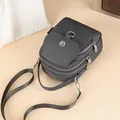 Dark grey nylon crossbody phone bag with triple zipper layers and metal logo detail - Gray