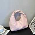 Rosa minimalistische Hobo-Tasche mit geknotetem Griff auf einem Lifestyle-Hintergrund - Rosa