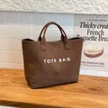 Μεγάλη καφέ σουέτ τσάντα tote με λευκά γράμματα TOTE BAG και ρετρό μινιμαλιστικό στυλ - Καφέ