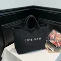 Classic black suede tote bag with white TOTE BAG lettering for casual commuting use - Black