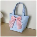 Detail of light blue canvas tote bag with silver stars and a large pink satin bow decoration - Blue with Charm