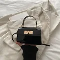 Borsa a mano minimalista in pelle verniciata nera con chiusura a scatto dorata - Nero