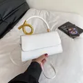 Elegante weiße Kunstledertasche mit einem markanten goldenen Metallgriff in Spiralform - Weiß