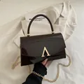 Sac à main verni marron chocolat avec fermoir doré en forme de A et bandoulière chaîne - Marron