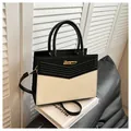 Elegante bolso bandolera bicolor en blanco y negro con logo dorado y costuras en V - Negro