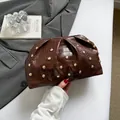 Bolso de mano marrón con textura de cocodrilo, remaches dorados y diseño plisado - Marrón