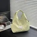 Light green canvas tote bag with star patterns and dog embroidery on black desk - Green