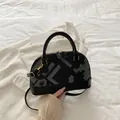 Schwarze Muschel-Handtasche mit grauem geometrischem Muster und goldener Kette - Grau