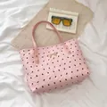 Bolso tote rosa con estampados de lazos negros y colgante dorado en tela texturizada - Rosa