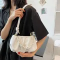 Borsa a nuvola bianca con manico di perle e tracolla indossata da una modella - Bianco