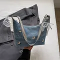 Borsa sottobraccio in denim blu con borchie a farfalla argento e ciondolo di perle - Con Ciondolo / Blu Denim