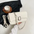 Cream white underarm bag with silver buckle and lychee texture in a lifestyle setting - Off White