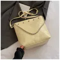 Bolso saco amarillo acolchado con asa de cadena y detalles de tachuelas - Amarillo