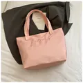 Pink satin tote bag featuring chic embroidery and elegant ruffled handles on fabric - Pink