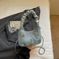 Borsa a mano in denim blu con fiocco argento e tracolla a catena metallica - Celeste