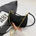 Black embossed cartoon crossbody bag with gold chain strap and textured leather finish - Black