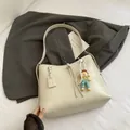 Minimalist creamy white large tote bag with pearl and doll charm on a grey suit jacket - White With Pendant