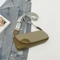 Olivgrüne Baguette-Schultertasche mit geometrischem Schultergurt auf Denim - Grün