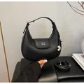 Black litchi pattern leather half-moon bag with top handle and silver bean charm - Black