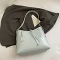 Minimalist light blue leather tote bag with decorative pendant and shoulder strap - Blue Without Charm