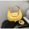 Chic yellow lychee pattern crescent handbag with heart charm and adjustable strap - Yellow