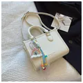 Weiße Handtasche mit Litschimuster, buntem Regenbogen-Anhänger und Schultergurt - Mit Ornament / Gebrochenes Weiß
