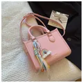Minimalistische hellrosa Handtasche aus Litschi-Leder mit Regenbogen-Anhänger und Gurt - Mit Ornament / Rosa