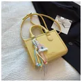 Schicke gelbe Handtasche mit Litschistruktur, Regenbogenanhänger und Schultergurt - Mit Ornament / Gelb