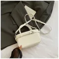 Sac à main blanc minimaliste avec boucle décorative sur blazer gris foncé - Blanc