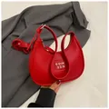 Bolso hobo rojo con textura de lichi y logo plateado sobre un fondo minimalista - Rojo