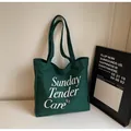Dettaglio della borsa tote in tela verde scuro con stampa di lettere Sunday Tender - Verde