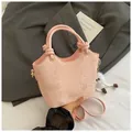 Detalle de bolso tipo cubo rosa con patrón de serpiente, colgante de felpa y logo dorado - Con Ornamento / Rosa