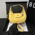 Elegante borsa a mezzaluna giallo acceso in pelle martellata con ciondolo a cuore - Giallo