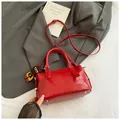 Red crocodile embossed bowling handbag with adjustable strap and bear charm accessory - Red with Pendant