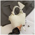 Detalle de bolso crema con motivo de serpiente y asa de nudo sobre un blazer gris elegante - Con Ornamento / Blanco