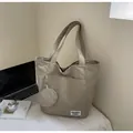Gros plan du sac fourre-tout kaki avec porte-monnaie assorti et étiquette de marque - Kaki