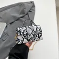 Mini borsa a mano con stampa a serpente, catena a sfere dorate e manico superiore - Nero